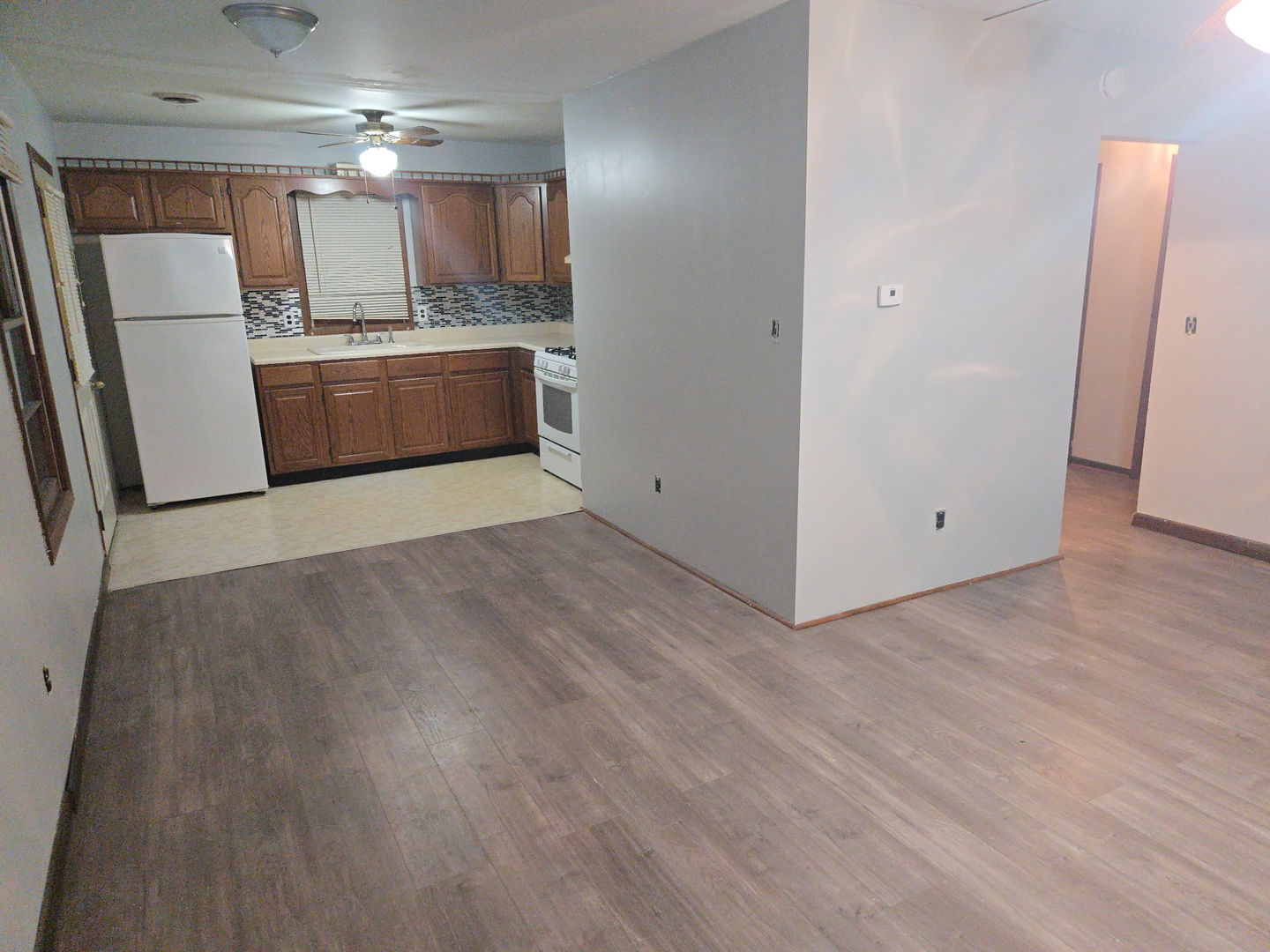 607 West Bluff Street Marseilles, IL 61341 - Photo 2 of 8 an empty room with wooden floor and a refrigerator