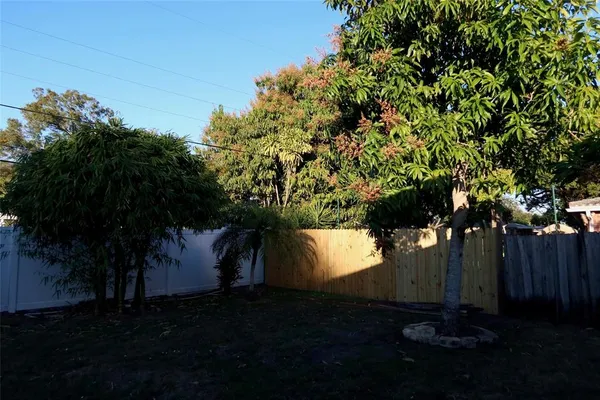a view of backyard with wooden fence