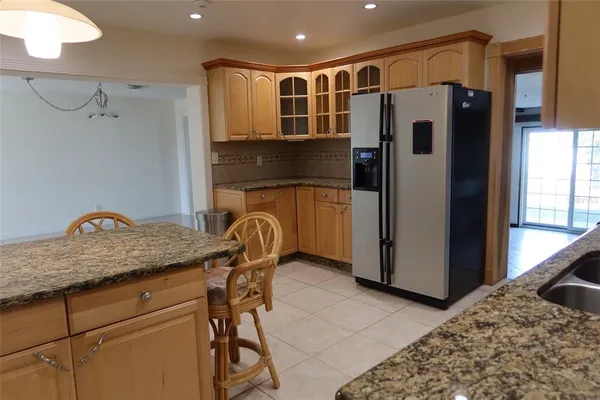a kitchen with stainless steel appliances granite countertop a refrigerator and a sink