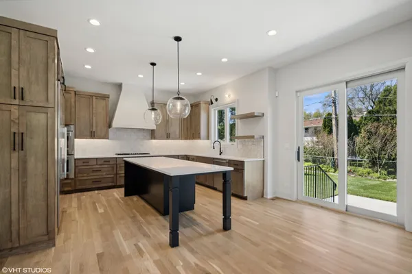 a large kitchen with kitchen island a stove a sink dishwasher and a refrigerator