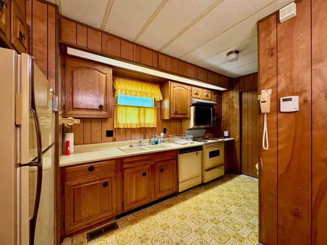 a large kitchen with stainless steel appliances granite countertop a refrigerator and a sink