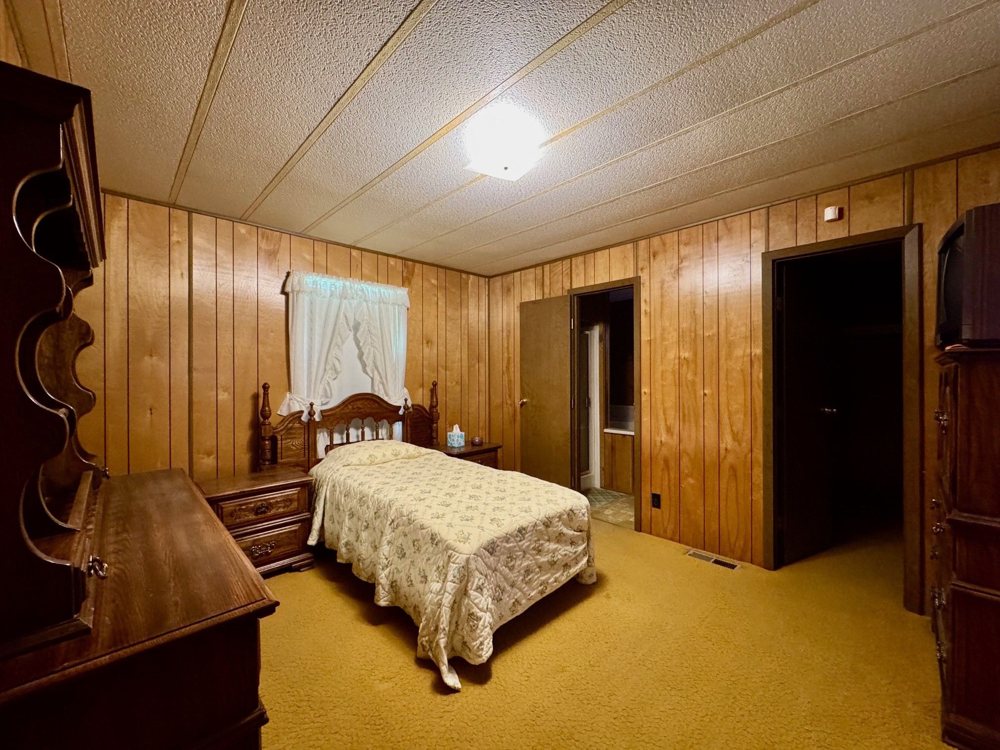 219 An County Road 185 Elkhart, TX 75839 - Photo 28 of 36 a bedroom with a bed and dresser with wooden floor
