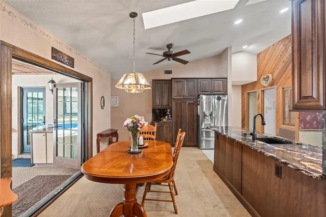 a view of a dining room with furniture a chandelier and wooden floor