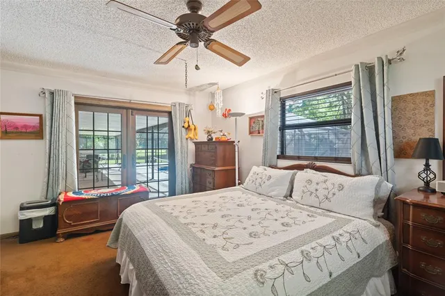 a bedroom with a large bed and a chandelier fan
