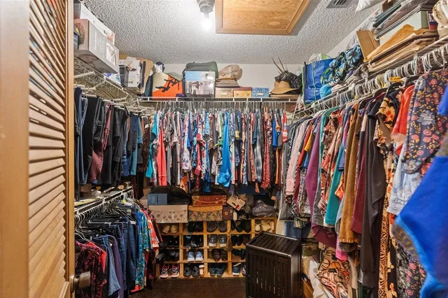 a view of walk in closet with clothes