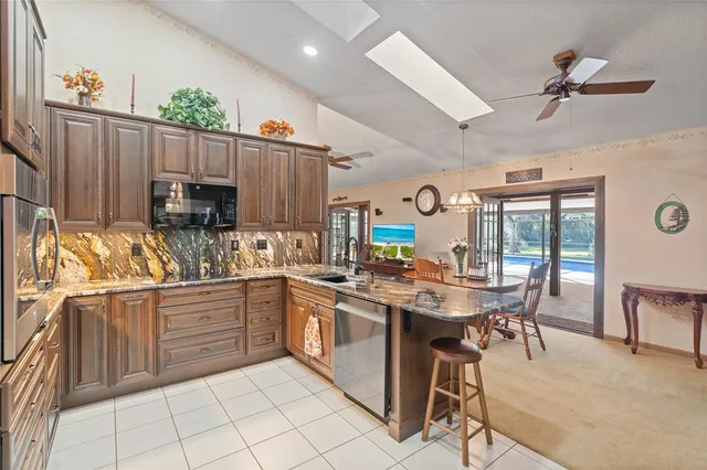 a kitchen with stainless steel appliances granite countertop a stove top oven a sink dishwasher and cabinets