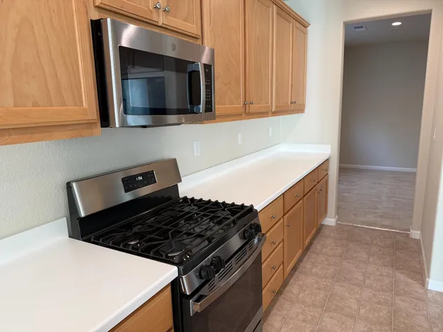 a kitchen with stainless steel appliances a stove a microwave and sink