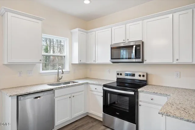 a bathroom with a granite countertop sink a toilet and a mirror