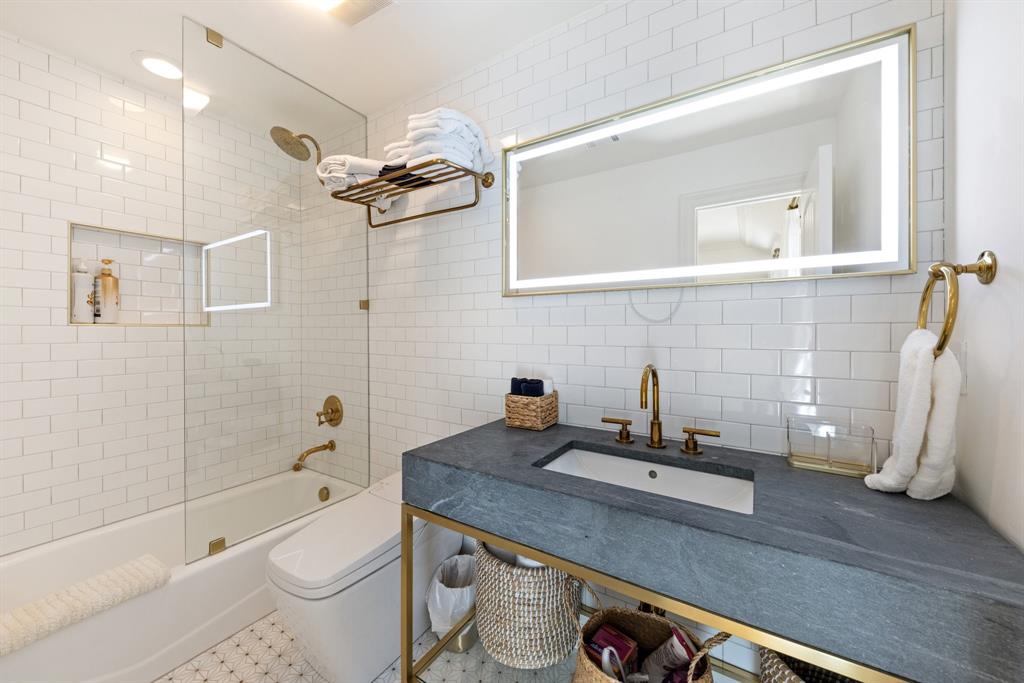 2 Terrabella Lane Heath, TX 75032 - Photo 26 of 40 a bathroom with a granite countertop sink a toilet a mirror and bathtub