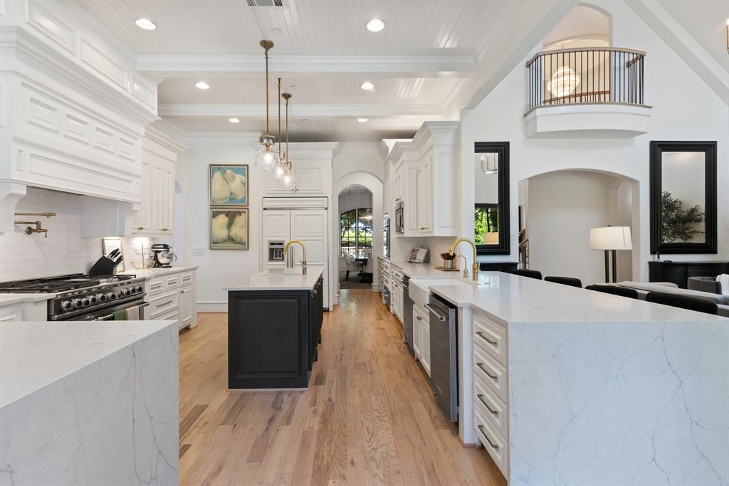 2 Terrabella Lane Heath, TX 75032 - Photo 8 of 40 a large kitchen with stainless steel appliances kitchen island a large counter top a stove a chimney a sink and a refrigerator