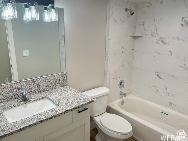 702 North 100 West Logan, UT 84321 - Photo 58 of 58 Bathroom featuring toilet, vanity, and shower / bathing tub combination