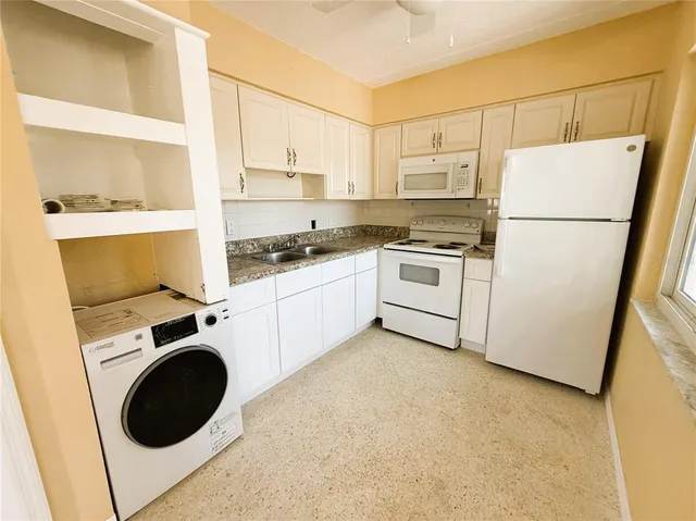a kitchen with a refrigerator sink stove and cabinets