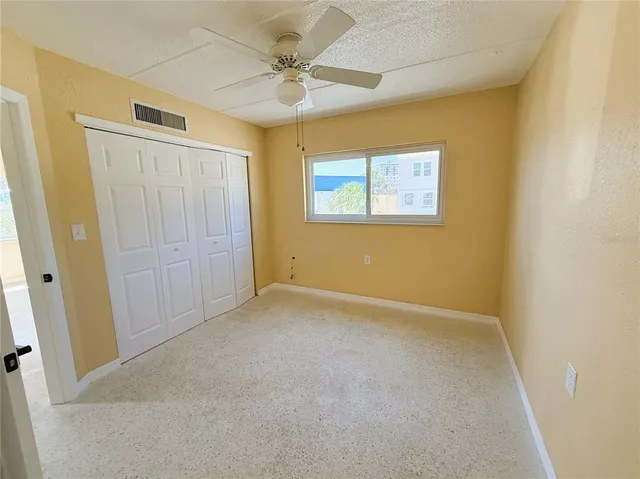 an empty room with a ceiling fan and a window
