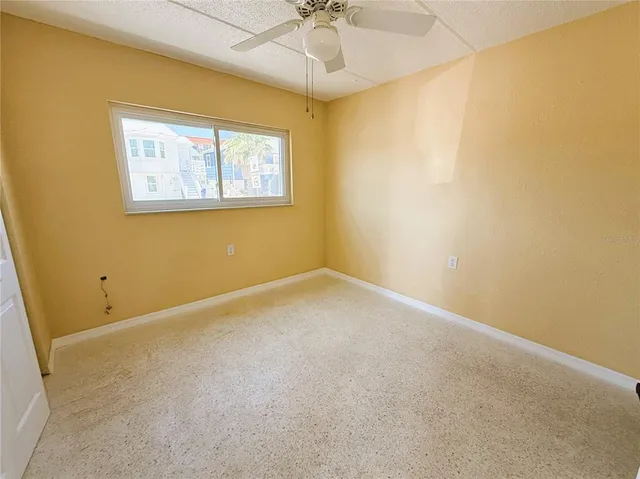 an empty room with a window and a ceiling fan