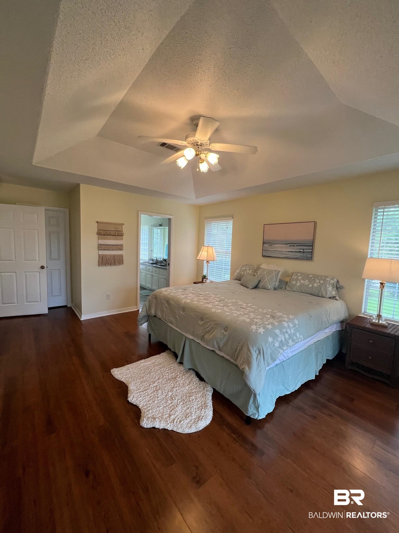 2204 Club House Drive Lillian, AL 36549 - Photo 11 of 38 Bedroom featuring a raised ceiling, wood finished floors, a textured ceiling, a ceiling fan, and vaulted ceiling