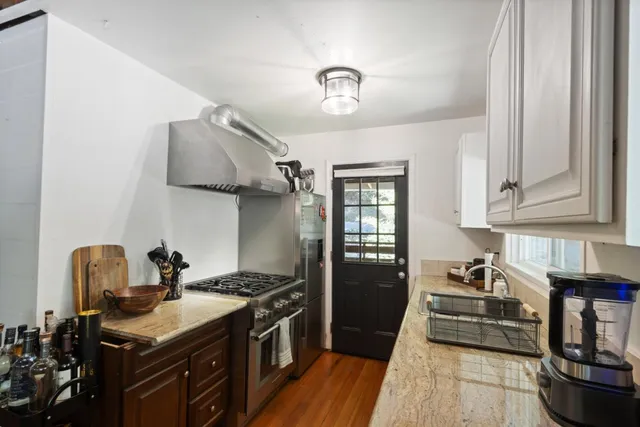 a kitchen with stainless steel appliances granite countertop a sink stove and cabinets