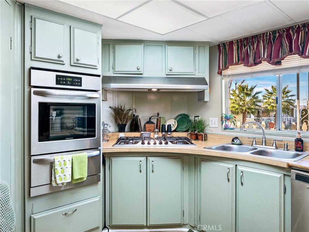 21922 Ottawa Road, Unit 8 Apple Valley, CA 92308 - Photo 12 of 31 a kitchen with stainless steel appliances a sink and cabinets