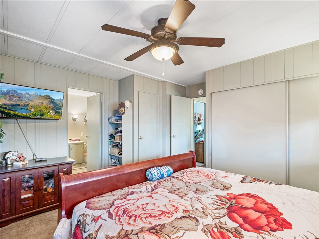 21922 Ottawa Road, Unit 8 Apple Valley, CA 92308 - Photo 21 of 31 a bedroom with a bed and a chandelier