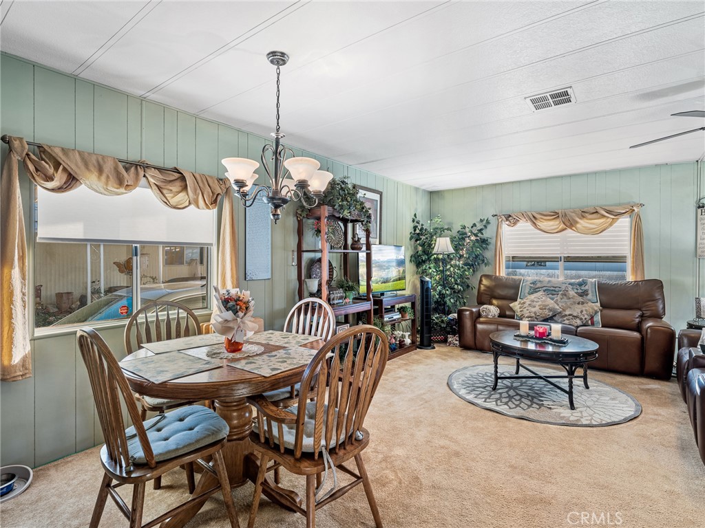 21922 Ottawa Road, Unit 8 Apple Valley, CA 92308 - Photo 10 of 31 a dining room with furniture a chandelier and window