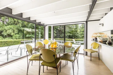 a dining room with furniture and a floor to ceiling window