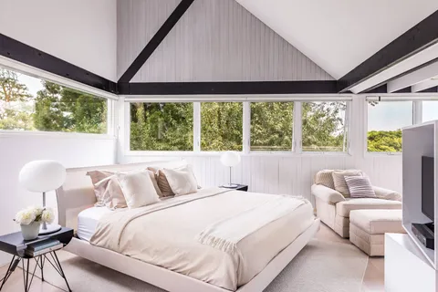 a bedroom with a bed and a large window