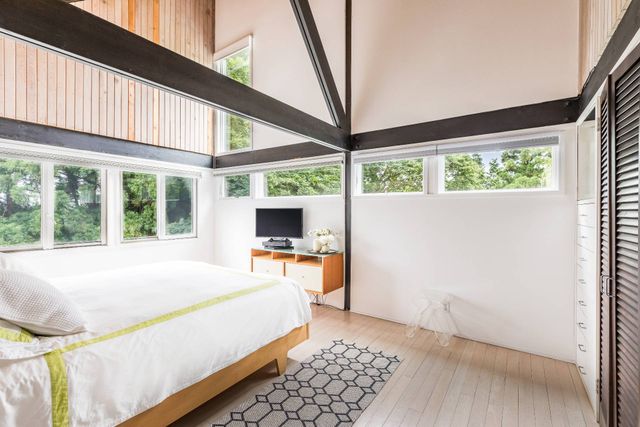 a bedroom with a bed and a large window