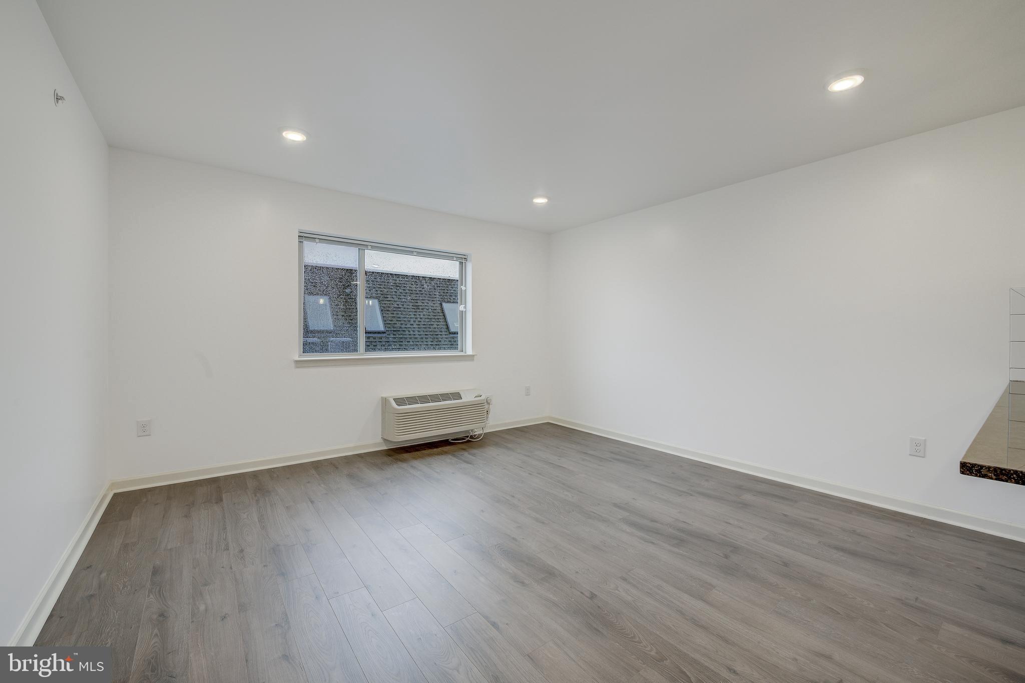 6649 Ridge Avenue, Unit C406 Philadelphia, PA 19128 - Photo 6 of 10 a view of an empty room with wooden floor and a window