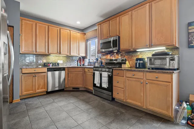 a kitchen with stainless steel appliances granite countertop a stove sink microwave and cabinets