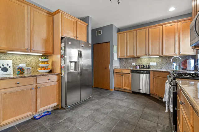 a kitchen with stainless steel appliances granite countertop a refrigerator sink and cabinets