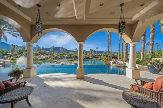 a living room with furniture a chandelier and a large window