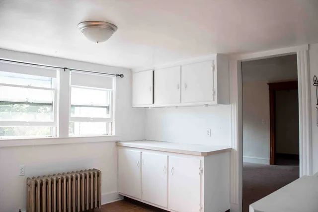 a room with a window and a kitchen view