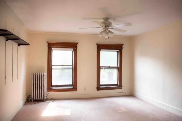 an empty room with windows and fan