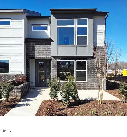 a front view of a house with garden and garage