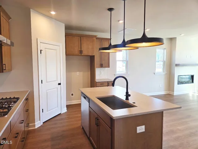 a kitchen with stainless steel appliances granite countertop a sink a refrigerator and a stove