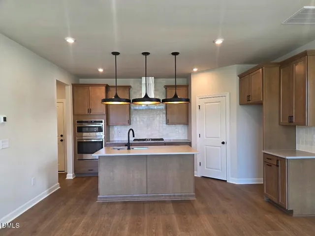 a kitchen with kitchen island stainless steel appliances a sink and refrigerator