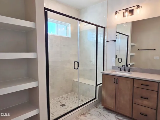 a bathroom with a shower sink and mirror