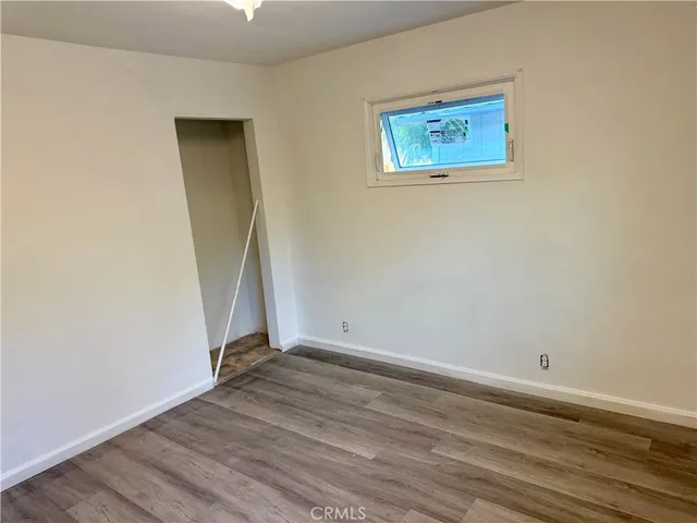 an empty room with wooden floor and white wall