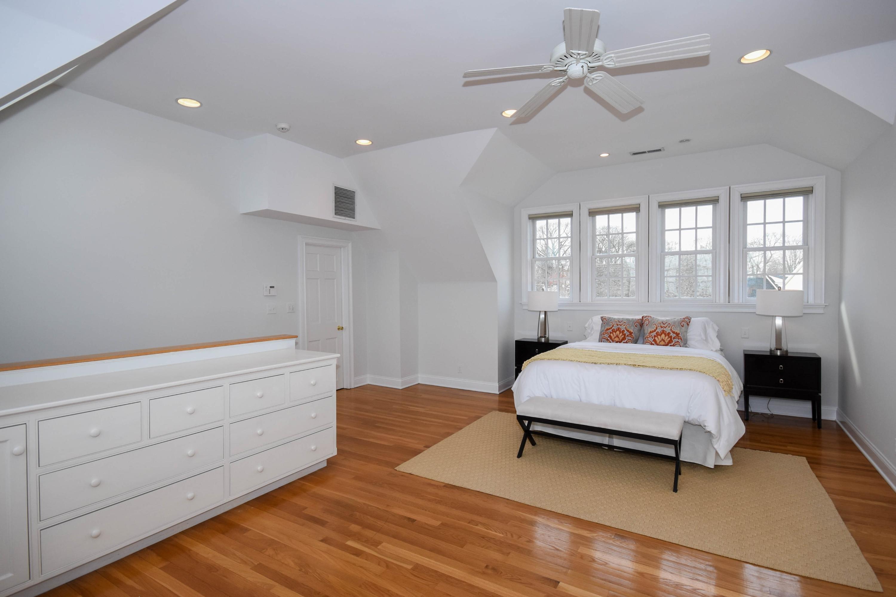 22 Meridian Road Rowayton, CT 06853 - Photo 16 of 25 a spacious bedroom with a bed and a chandelier