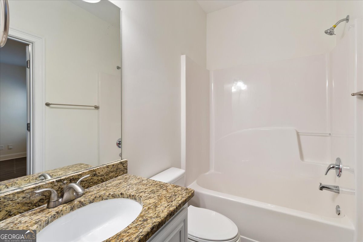 149 Mariahs Walk Hampton, GA 30228 - Photo 22 of 45 a bathroom with a granite countertop sink and a mirror
