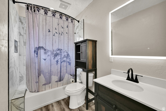 716 East Factory Street Garland, UT 84312 - Photo 18 of 30 Bathroom featuring a white vanity with an undermount sink, a backlit mirror, and a built-in over-toilet storage cabinet