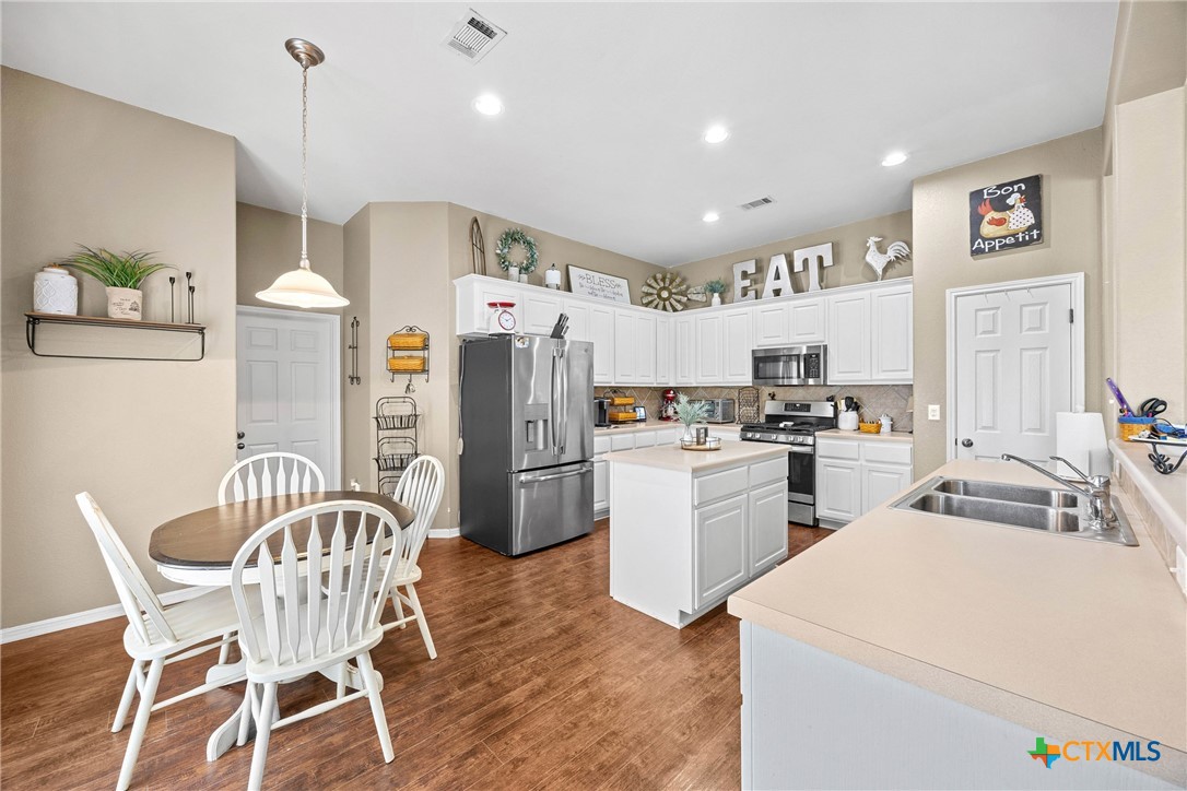 350 Lehne Road Bertram, TX 78605 - Photo 12 of 33 a kitchen with a sink a refrigerator and wooden floor