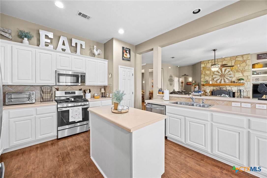 350 Lehne Road Bertram, TX 78605 - Photo 13 of 33 a kitchen with granite countertop white cabinets and white appliances