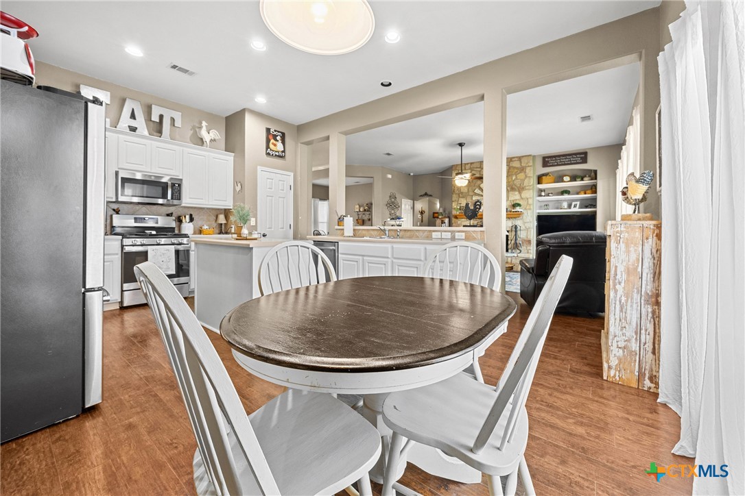 350 Lehne Road Bertram, TX 78605 - Photo 17 of 33 a dining room with stainless steel appliances granite countertop a table chairs and a refrigerator
