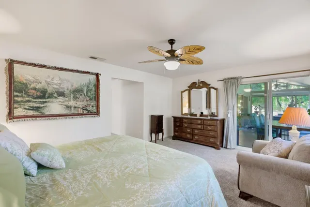 a bedroom with a bed a couch and a chandelier