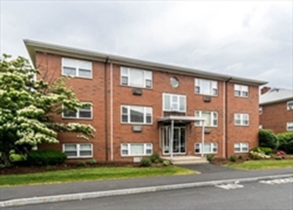 32 Whitman Road, Unit 12 Waltham, MA 02453 - Photo 1 of 19 a front view of a brick building next to a yard