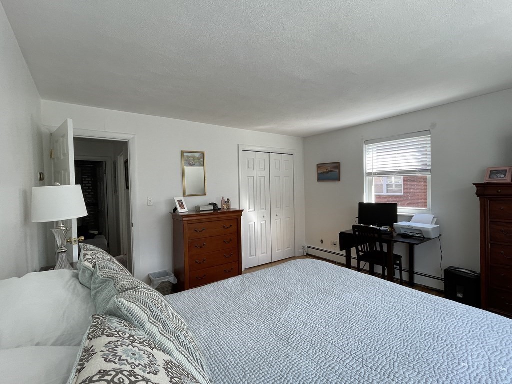 32 Whitman Road, Unit 12 Waltham, MA 02453 - Photo 13 of 19 a bedroom with a bed and a table in it