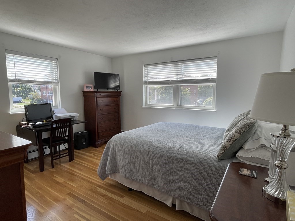 32 Whitman Road, Unit 12 Waltham, MA 02453 - Photo 14 of 19 a bedroom with a bed and a table in it