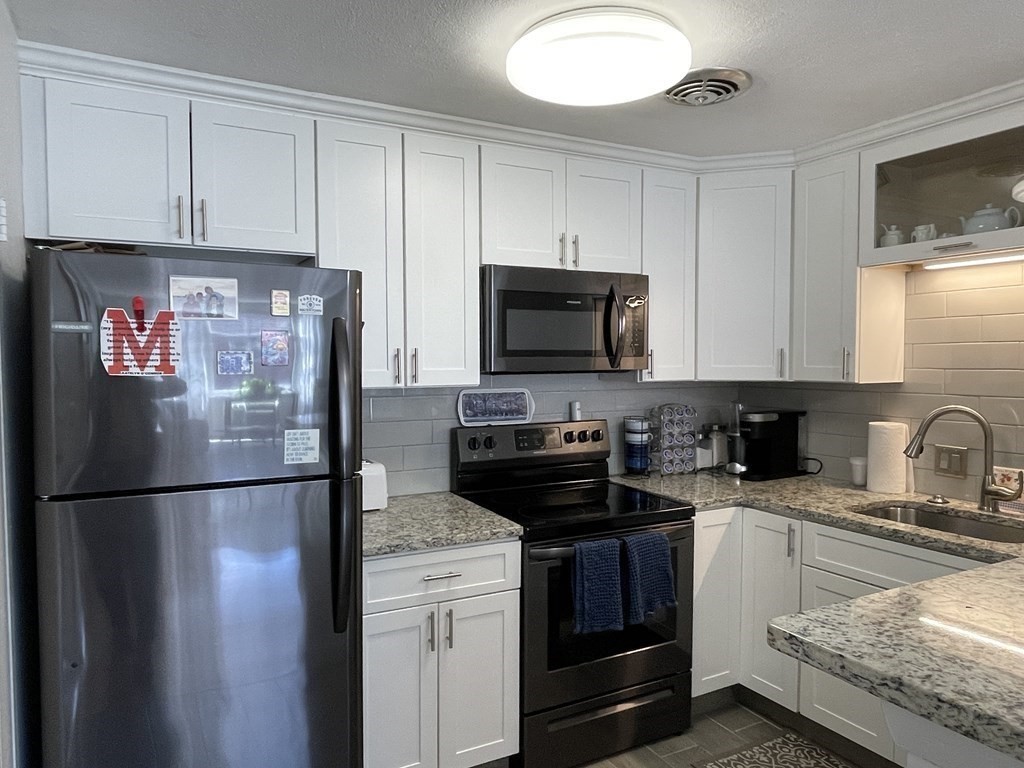 32 Whitman Road, Unit 12 Waltham, MA 02453 - Photo 2 of 19 a kitchen with a refrigerator and a sink
