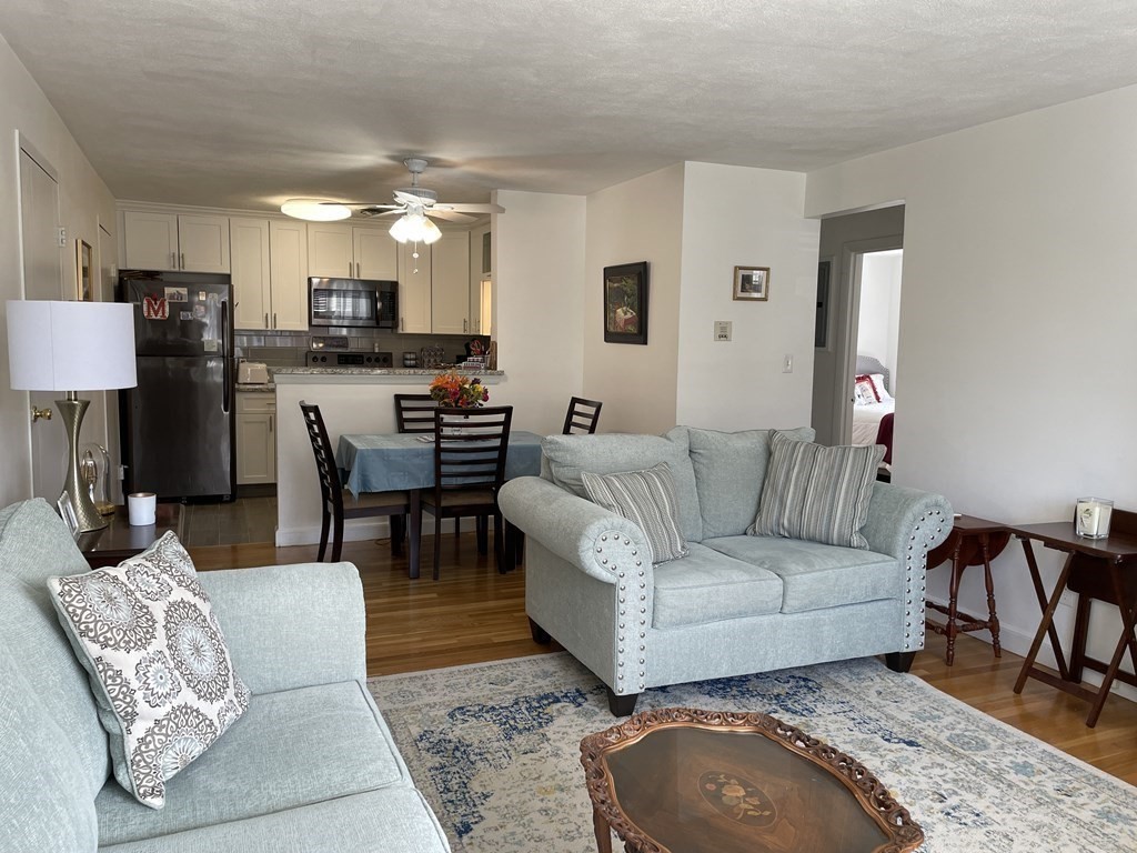 32 Whitman Road, Unit 12 Waltham, MA 02453 - Photo 8 of 19 a living room with furniture a wooden floor and a kitchen view