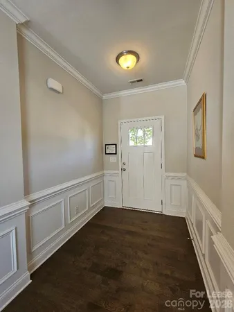 a view of an empty room with wooden floor and windows